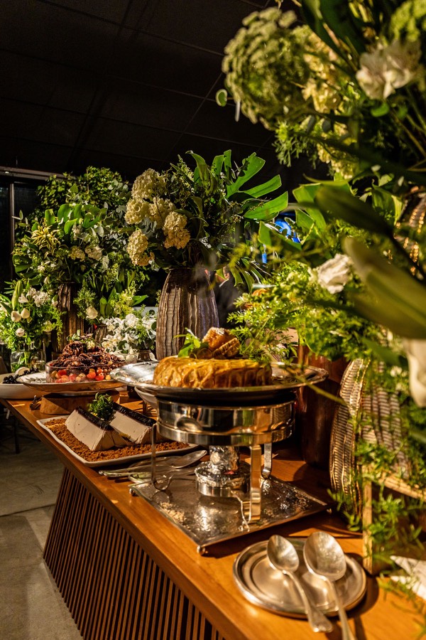 Mesa de buffet com flores e pratos quentes
