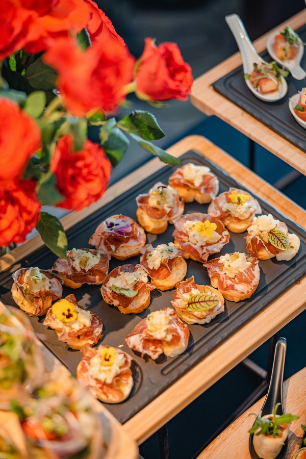 Composição premium com canapés e flores vermelhas