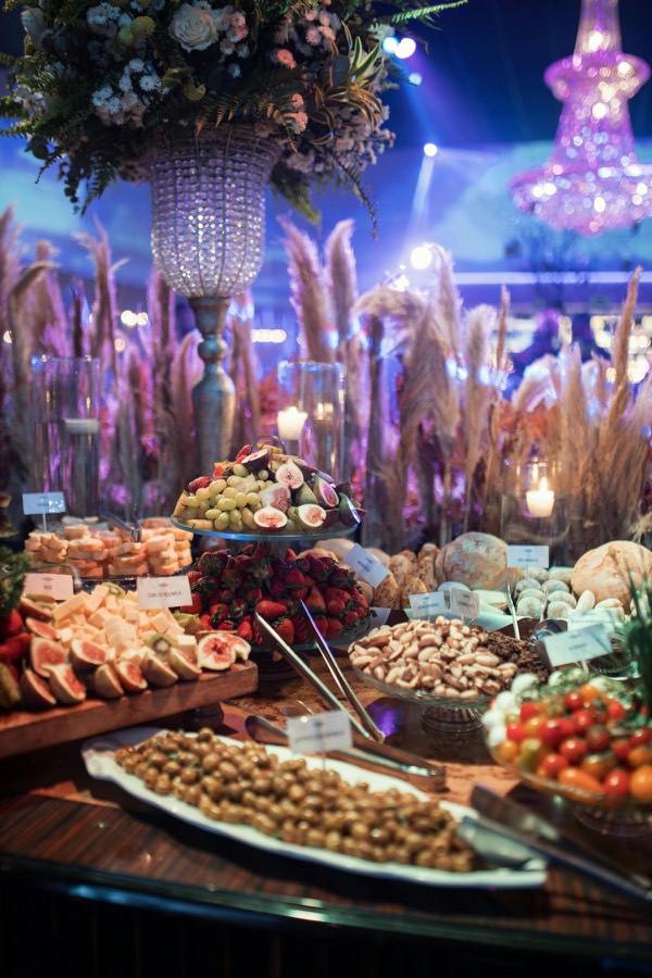 Buffet para casamento com frutas, flores e iluminação sofisticada