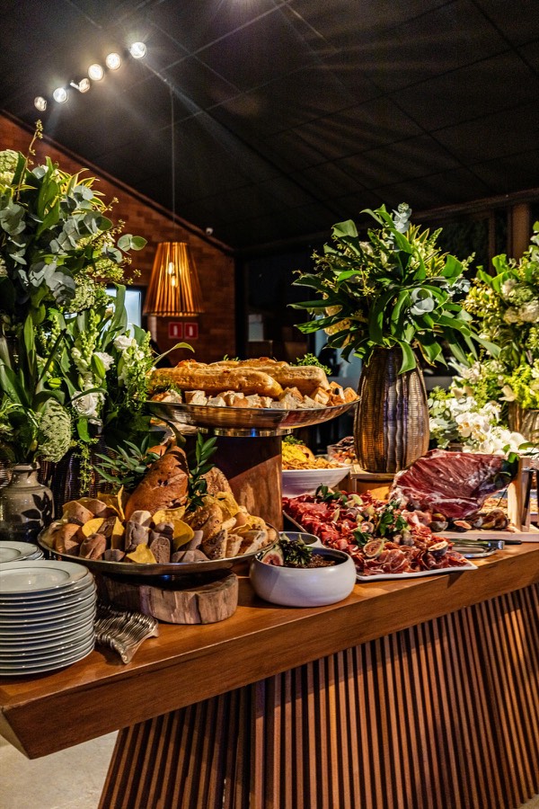 Jantar elegante com pães, frios e pratos refinados